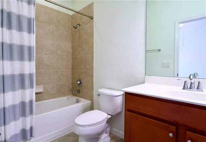 Bathroom featuring shower / bath combination with curtain and vanity