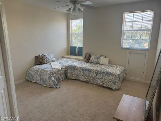 Carpeted bedroom with a ceiling fan