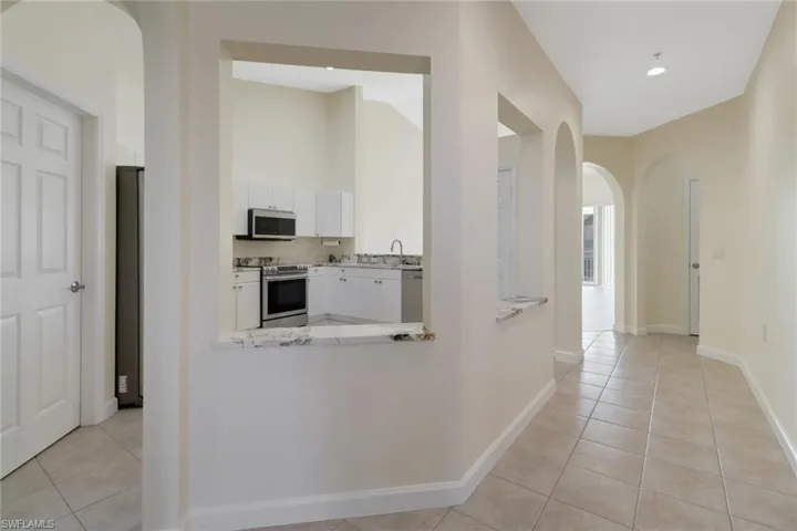 Hallway with light tile patterned floors and sink