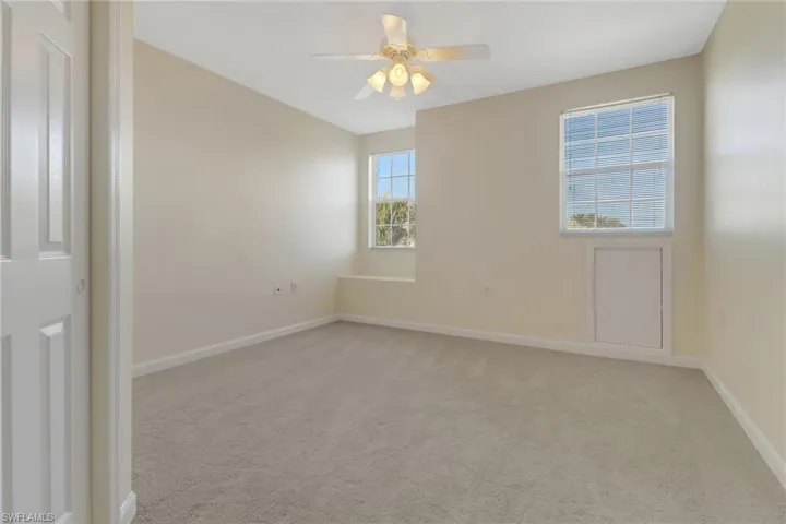 Carpeted empty room with ceiling fan