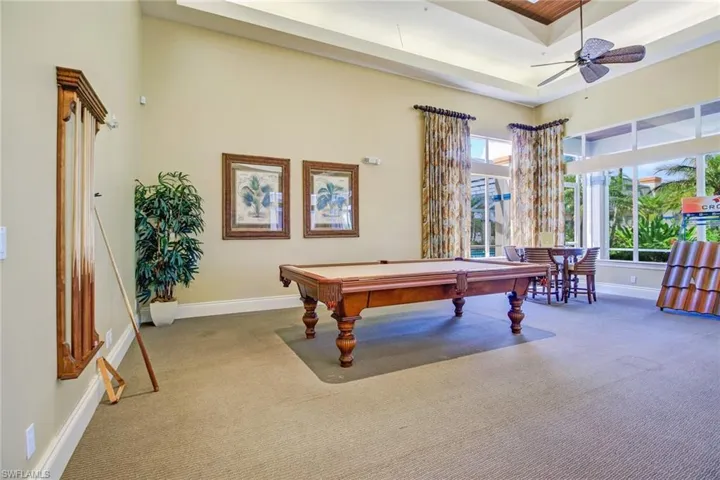 Playroom with a tray ceiling, billiards, ceiling fan, and carpet flooring