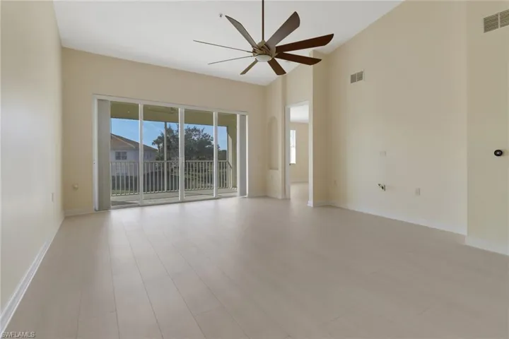 Empty room featuring ceiling fan, a wealth of natural light, and light wood-type flooring