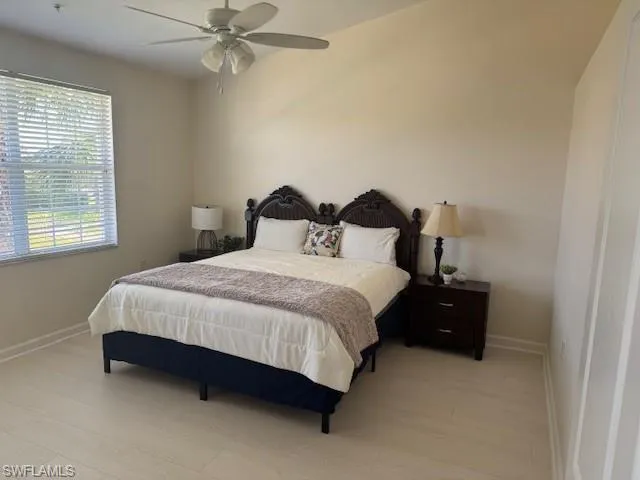 Bedroom with baseboards, ceiling fan, and light wood-style floors