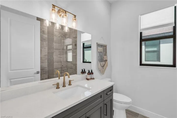 Bathroom featuring toilet, an enclosed shower, and vanity