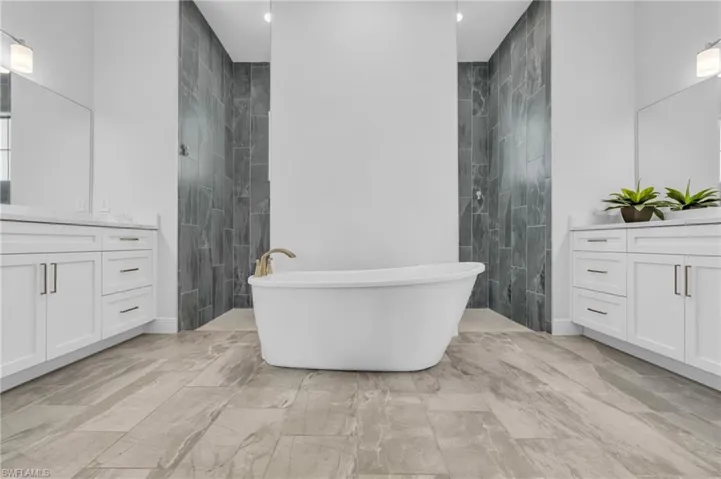 Bathroom with tile walls, vanity, and independent shower and bath