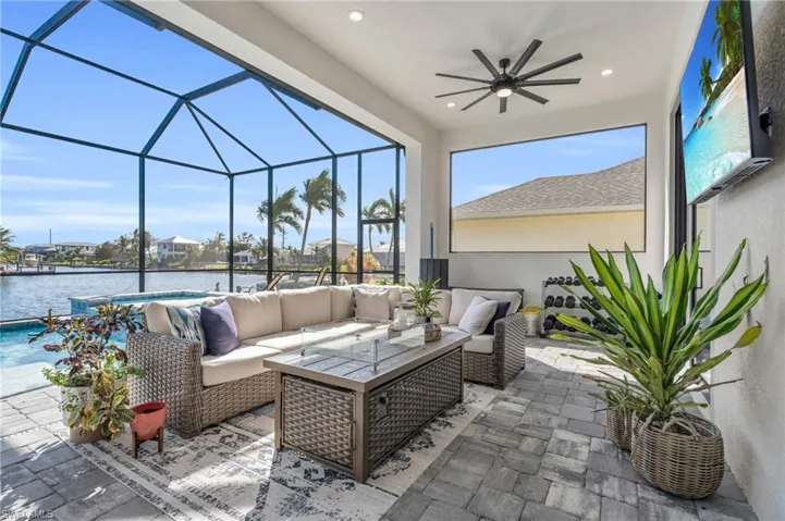 View of patio / terrace with an outdoor living space, a water view, glass enclosure, and ceiling fan