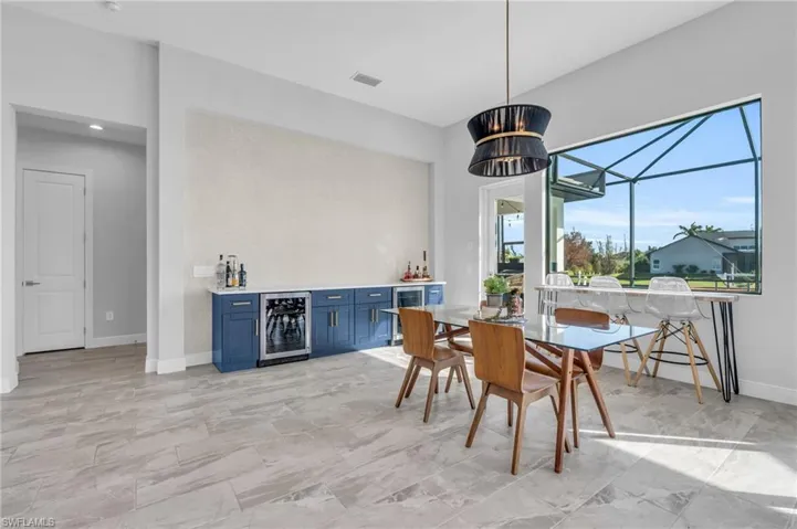 Dining area with wine cooler, a notable chandelier, and indoor bar