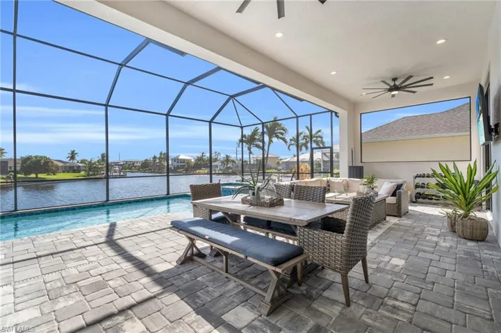 View of patio / terrace with an outdoor living space, ceiling fan, a water view, and a lanai