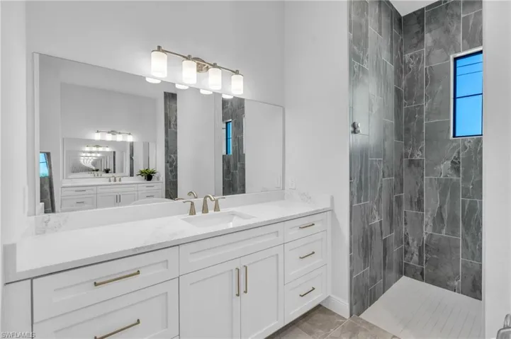 Bathroom with vanity and tiled shower