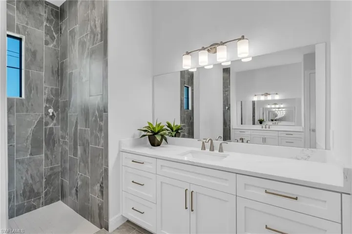 Bathroom featuring vanity and tiled shower