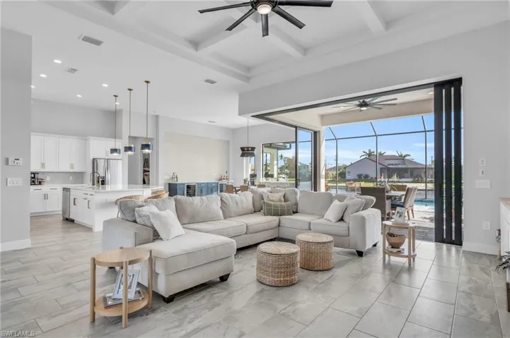 Living room featuring ceiling fan, coffered ceiling, and beamed ceiling