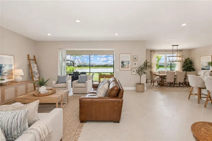 Expansive living area with large format tile flooring and recessed lighting