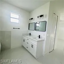 Full bathroom with double vanity and walk in shower