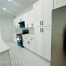 Kitchen featuring white cabinets, stainless steel appliances, and light countertops