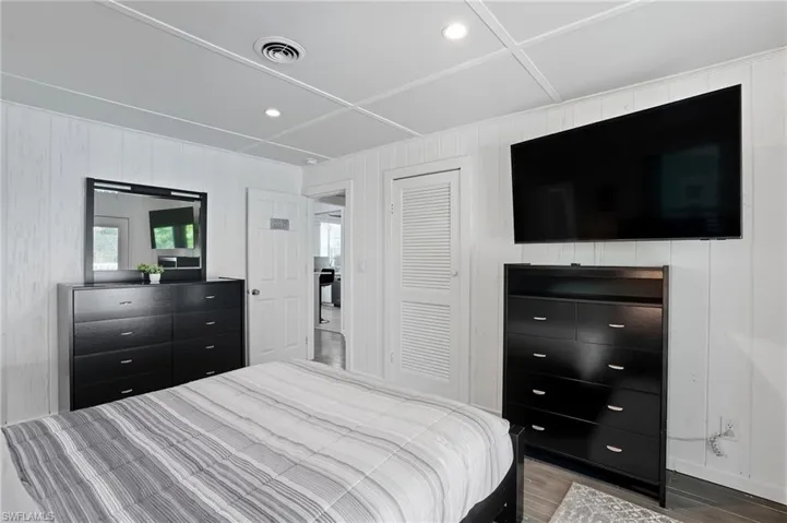 Bedroom with recessed lighting, wood finished floors, and a closet - Virtually Edited Image