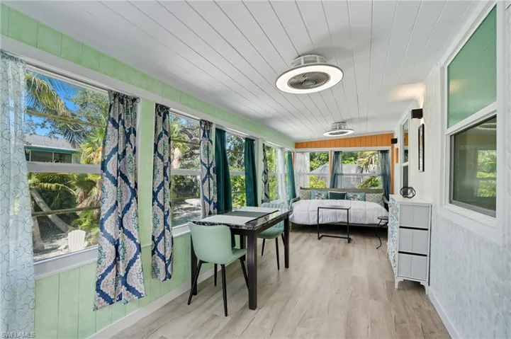 Sunroom with wood walls, wooden ceiling, and wood finished floors - Virtually Edited Image