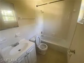 Bathroom with shower / washtub combination, vanity, and tile patterned floors