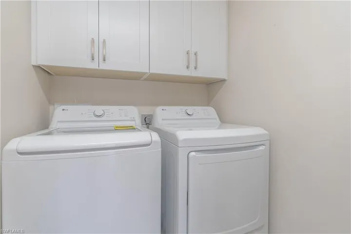 Laundry room featuring cabinets and new washing machine and new dryer
