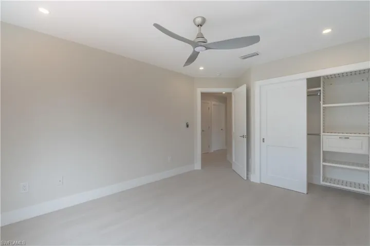 Unfurnished guest bedroom 2 with custom closet shelving, ceiling fan