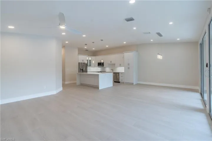 Unfurnished living room with light wood-style flooring and ceiling fan