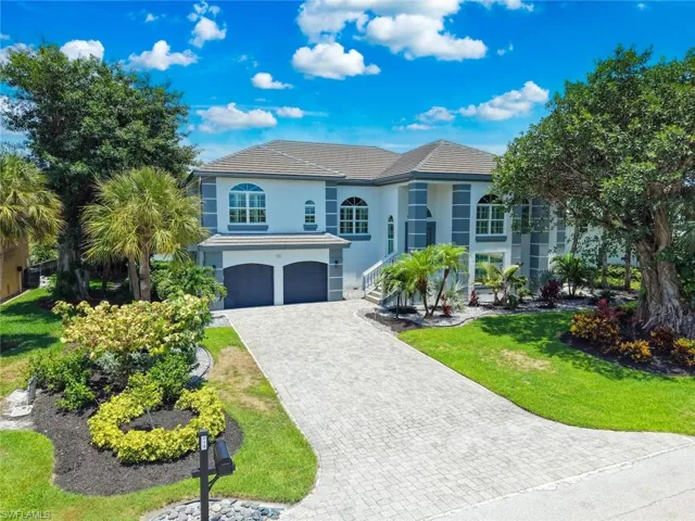 Two-story stucco residence featuring a tile roof and two-car garage