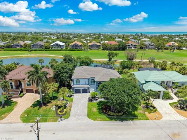 Coastal property featuring a golf course, water feature, and distant ocean scenery