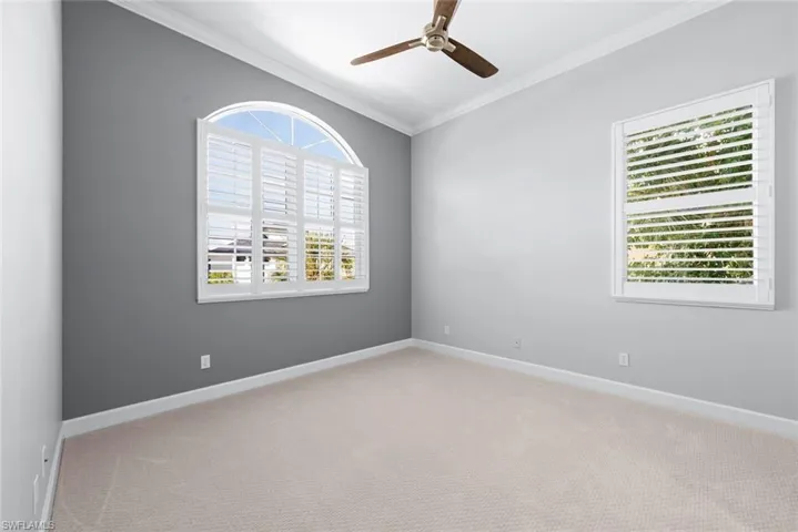 Spacious room featuring neutral carpeting and a ceiling fan
