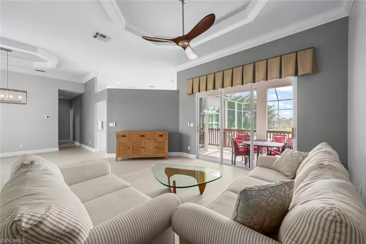 Expansive living area with tray ceilings and crown molding