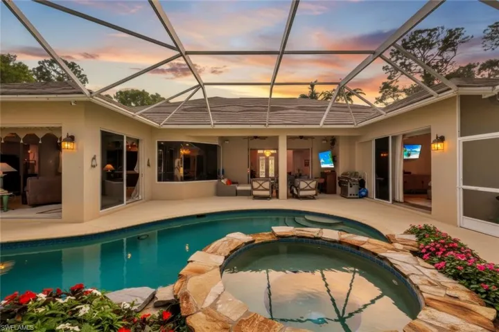 Relaxing pool / spa with a sunroom, glass enclosure, and a patio