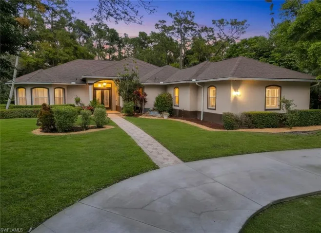 Ranch-style home featuring stucco siding, a front lawn, and a shingled roof