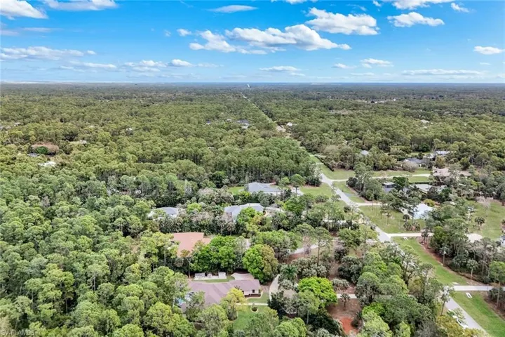Aerial view of property's location featuring a forest
