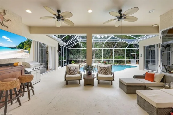 View of patio featuring a sunroom, ceiling fan, an outdoor pool, an outdoor lounge area, and a lanai