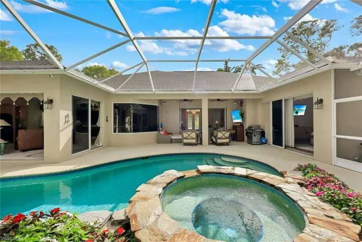 Integrated pool / hot tub featuring a sunroom, a patio area, and glass enclosure