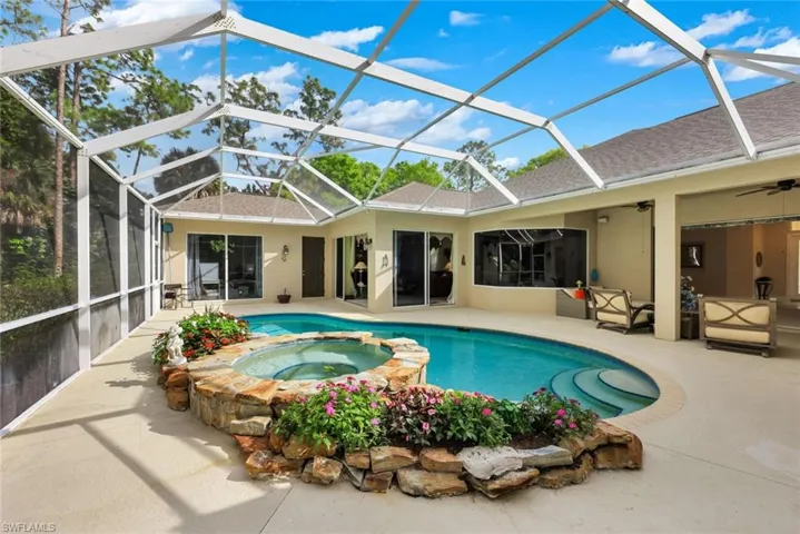 Rear view of house with a sunroom, a shingled roof, glass enclosure, and stucco siding