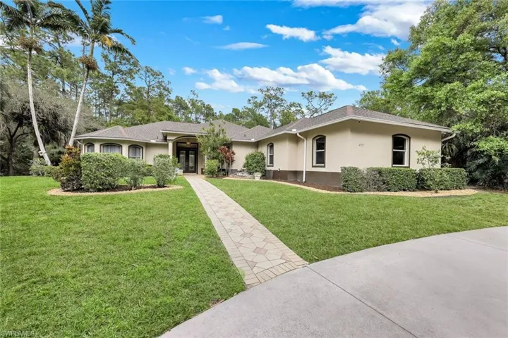 Single story home featuring stucco siding, a front lawn, and a shingled roof