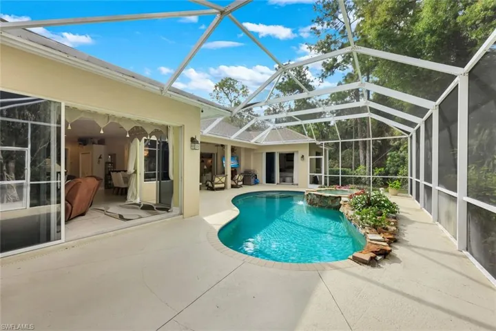 Relaxing pool / spa with a sunroom, glass enclosure, and a patio area