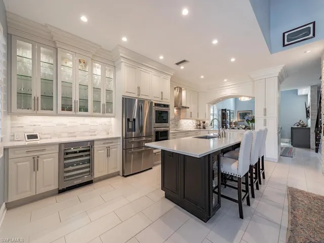 3760 Baldwin Ln, Naples FL 34116 - A Chef's dream kitchen with true double ovens, wine cooler, modern range hood and glass front cabinets