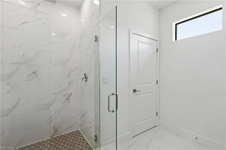 Master Bathroom featuring a marble finish shower and light marble finish floors