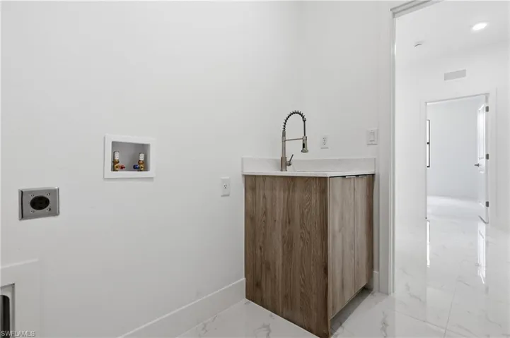 Laundry room featuring electric dryer hookup, light marble finish floors, and washer hookup