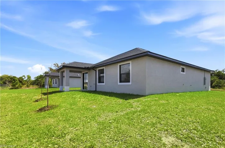 View of property exterior with a yard and stucco siding