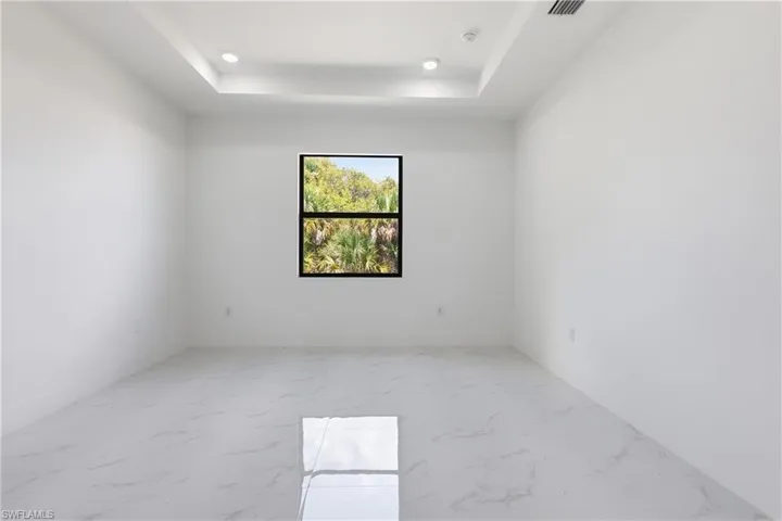 Master Bedroom with light marble finish flooring, a tray ceiling, and recessed lighting