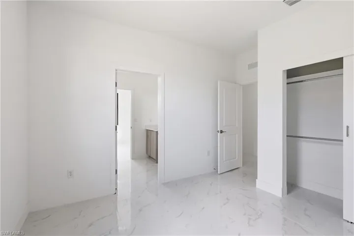 Bedroom featuring a closet and light marble finish flooring