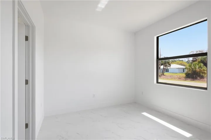 Bedroom featuring light marble finish floors and baseboards