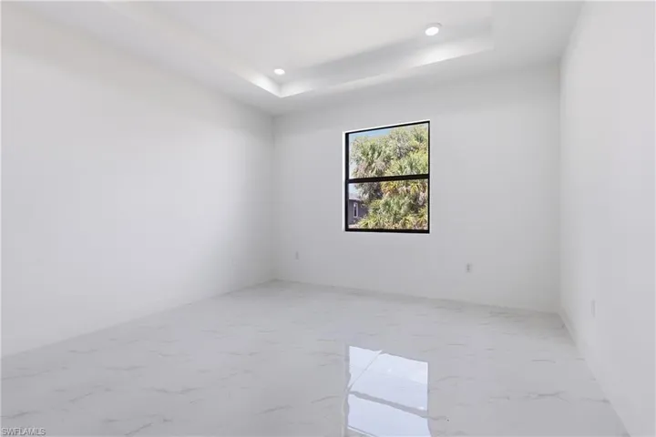 Master Bedroom with light marble finish floors, a raised ceiling, and recessed lighting