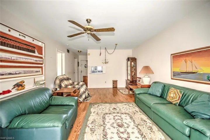 Living room with ceiling fan and light hardwood / wood-style floors