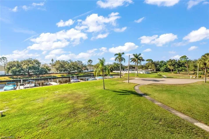 View of property's community with a lawn, a dock, and a water view