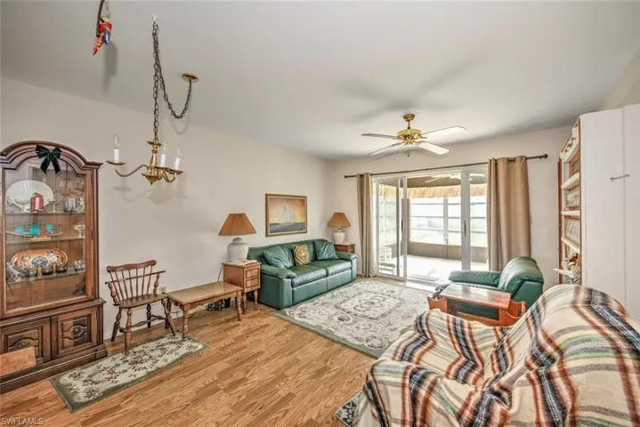 Living room featuring wood-type flooring and ceiling fan with notable chandelier