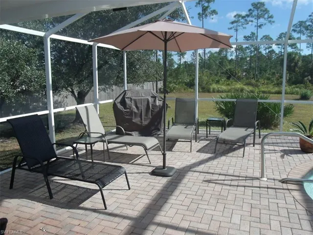 Fenced backyard featuring glass enclosure, a patio, and a grill