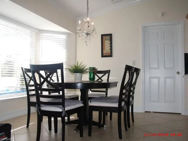 Tiled dining area with ornamental molding and a chandelier