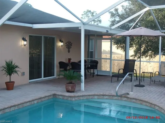 View of swimming pool featuring a patio area and a lanai